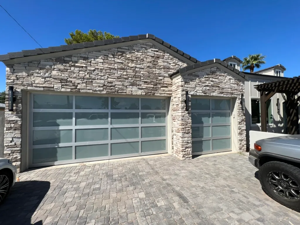 Glass garage door installed in a stacked stone wall